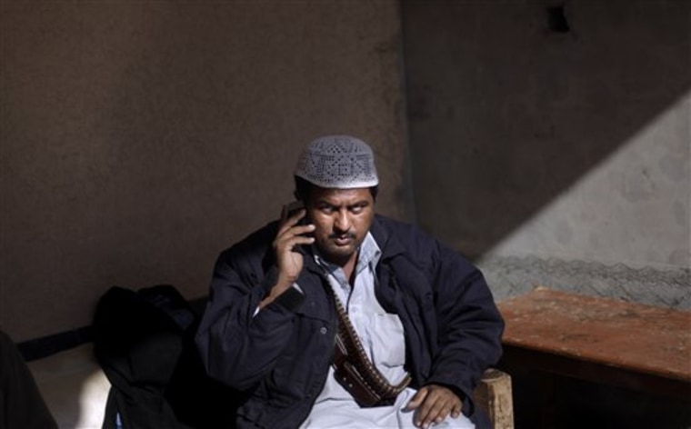 A Pakistani militant looks on while talking on a mobile phone at their headquarters in Peshawar, Pakistan. Tribal militias allied with the government helped block a Taliban advance in this corner of northwest Pakistan close to the Afghan border, but their success has come at a price: the empowerment of untrained, unaccountable private armies that could yet emerge as a threat of their own. 